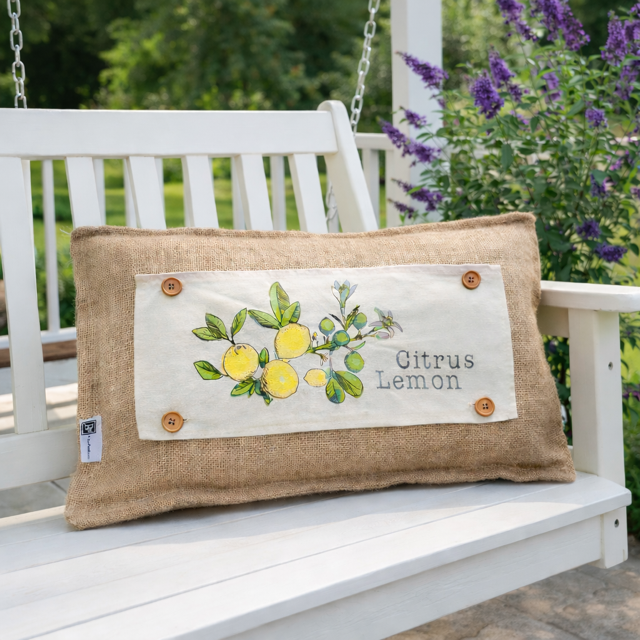 Decorative pillow with lemon design on a white bench outdoors