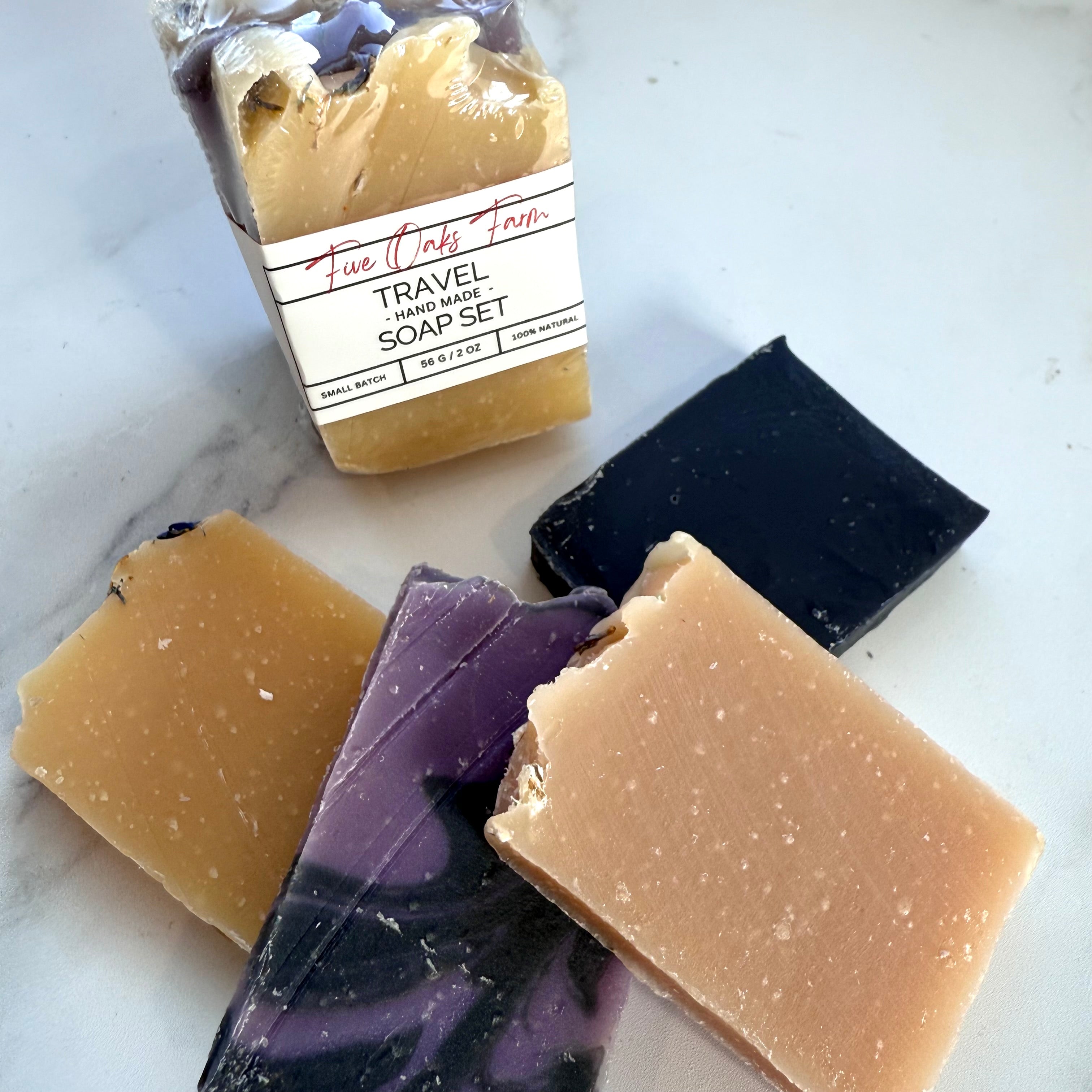 Travel soap set with four bars of soap on a marble surface