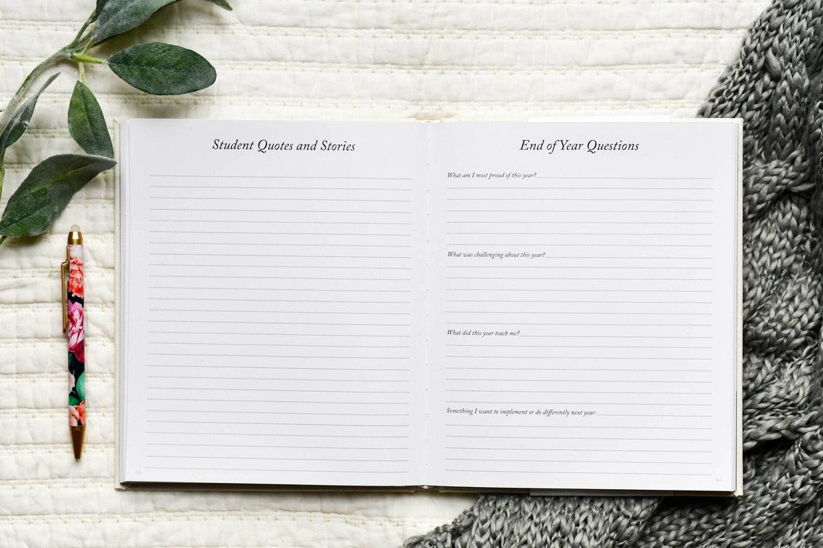 Notebook with lined pages on a textured surface with a pen and leaves.