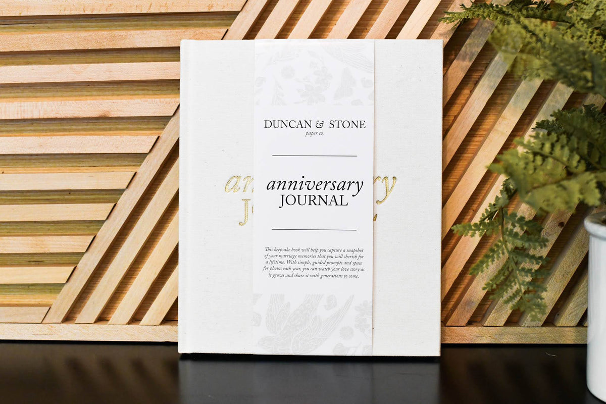 Ivory Anniversary Journal sitting against a wood gate
