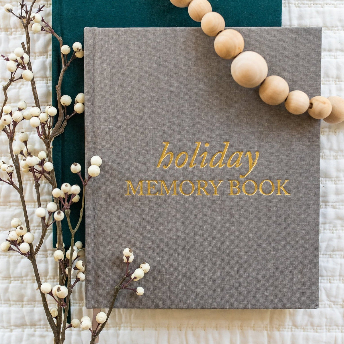 holiday memory book by Duncan & Stone surrounded by beads and dried flowers
