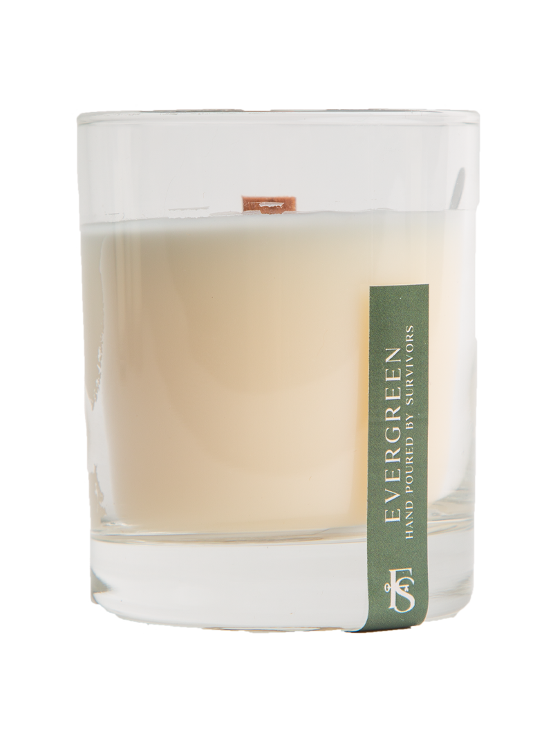 Candle in a glass jar with 'Evergreen' label on a white background