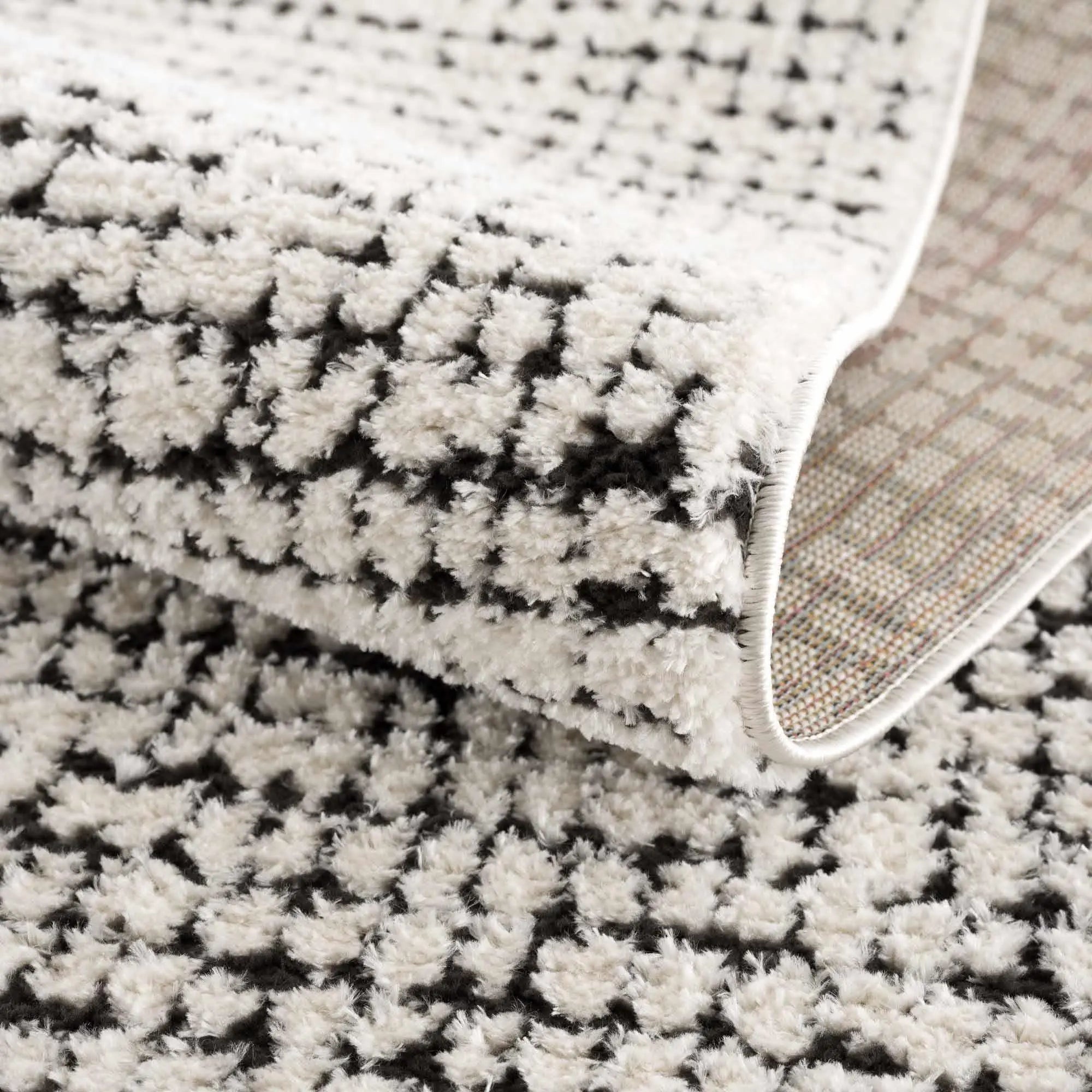 Cozy farmhouse area rug with black and cream geometric pattern, soft shag texture, perfect for living room decor