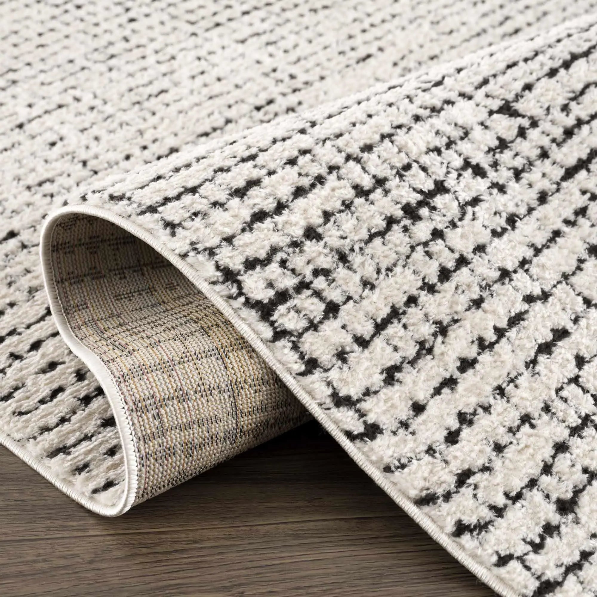 Cozy farmhouse rug with black and cream geometric pattern, soft textured weave on wood floor