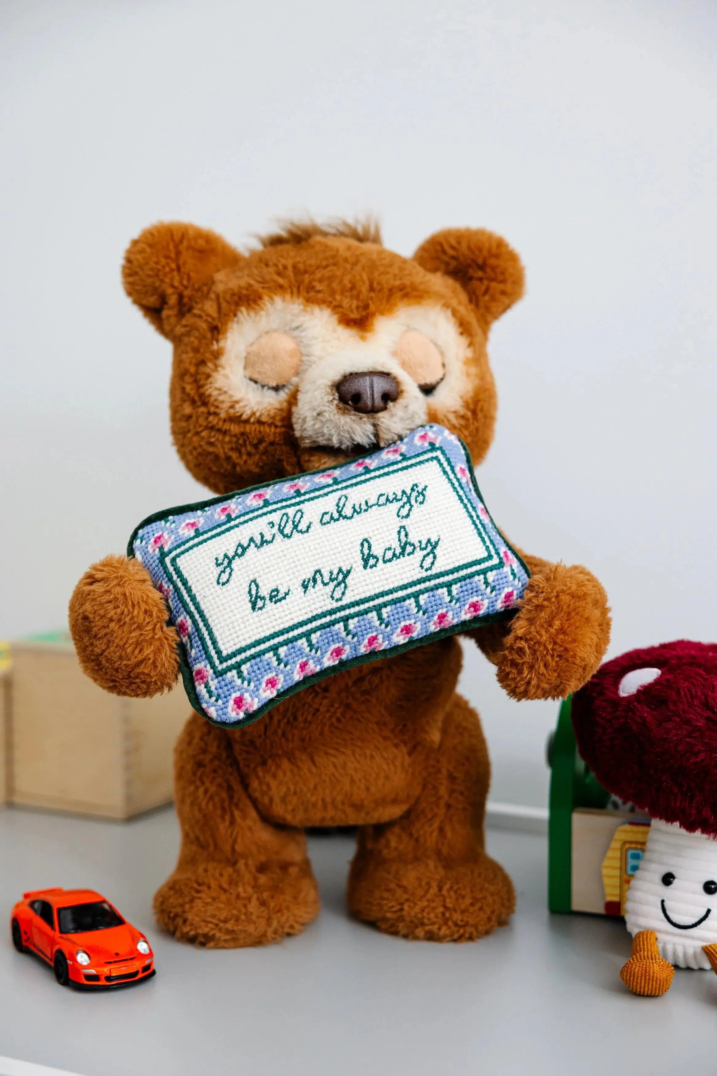 Cozy teddy bear holding 'you'll always be my baby' needlepoint pillow, farmhouse nursery decor