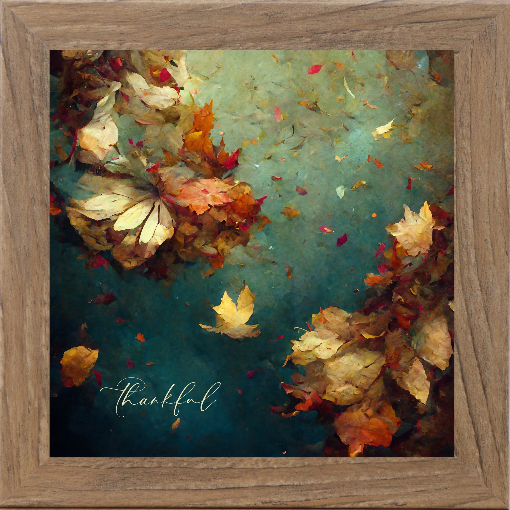 Framed artwork of autumn leaves with 'thankful' text on a teal background