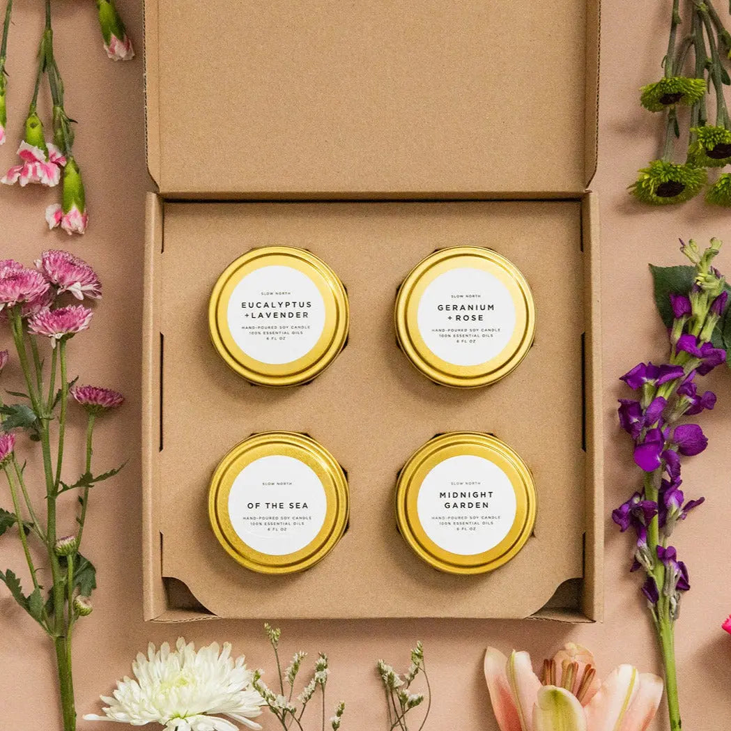 Four hand-poured soy candles in gold tins with floral accents, perfect for cozy farmhouse decor and thoughtful gifts.