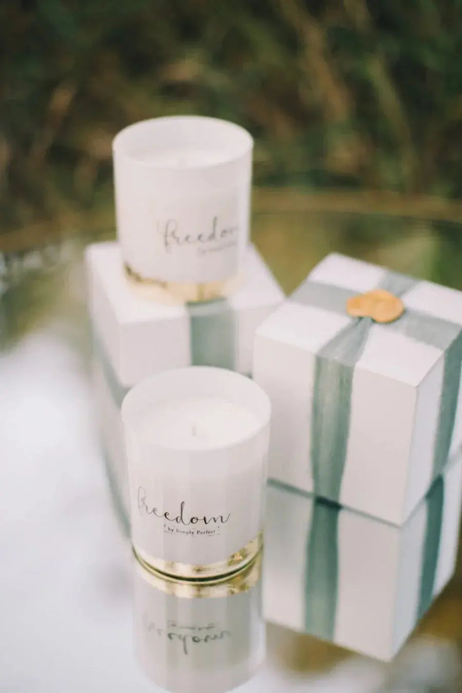 White 'Freedom' candles with gold accents, styled with gift boxes for cozy home decor and thoughtful gifting.