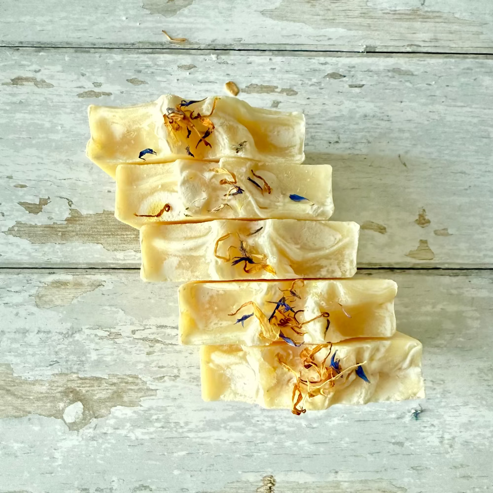 Stack of soap bars with natural elements on a wooden surface