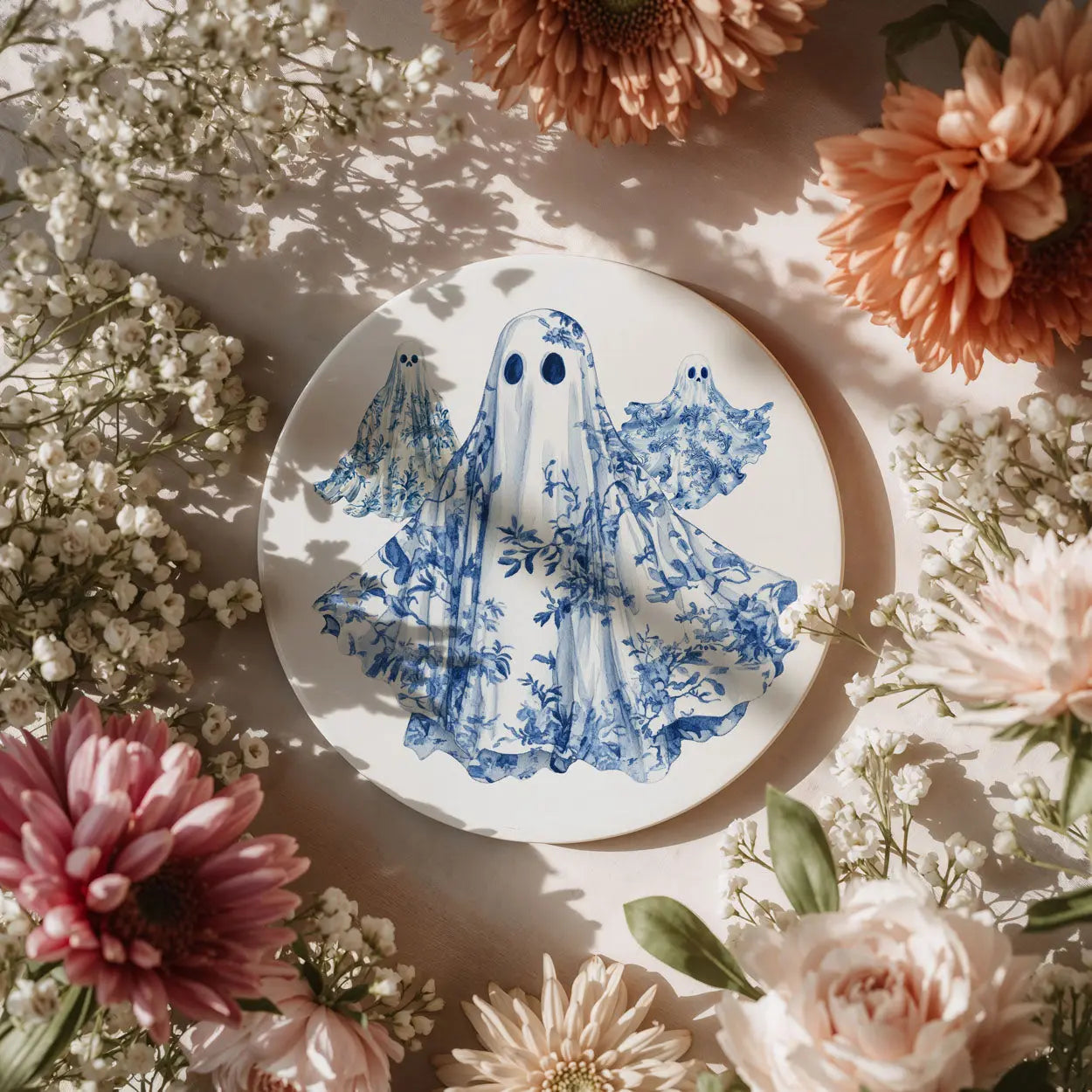 Decorative plate with blue ghost design surrounded by flowers