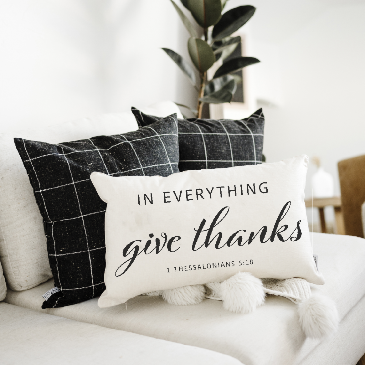 Decorative pillow with 'In everything give thanks' text on a couch