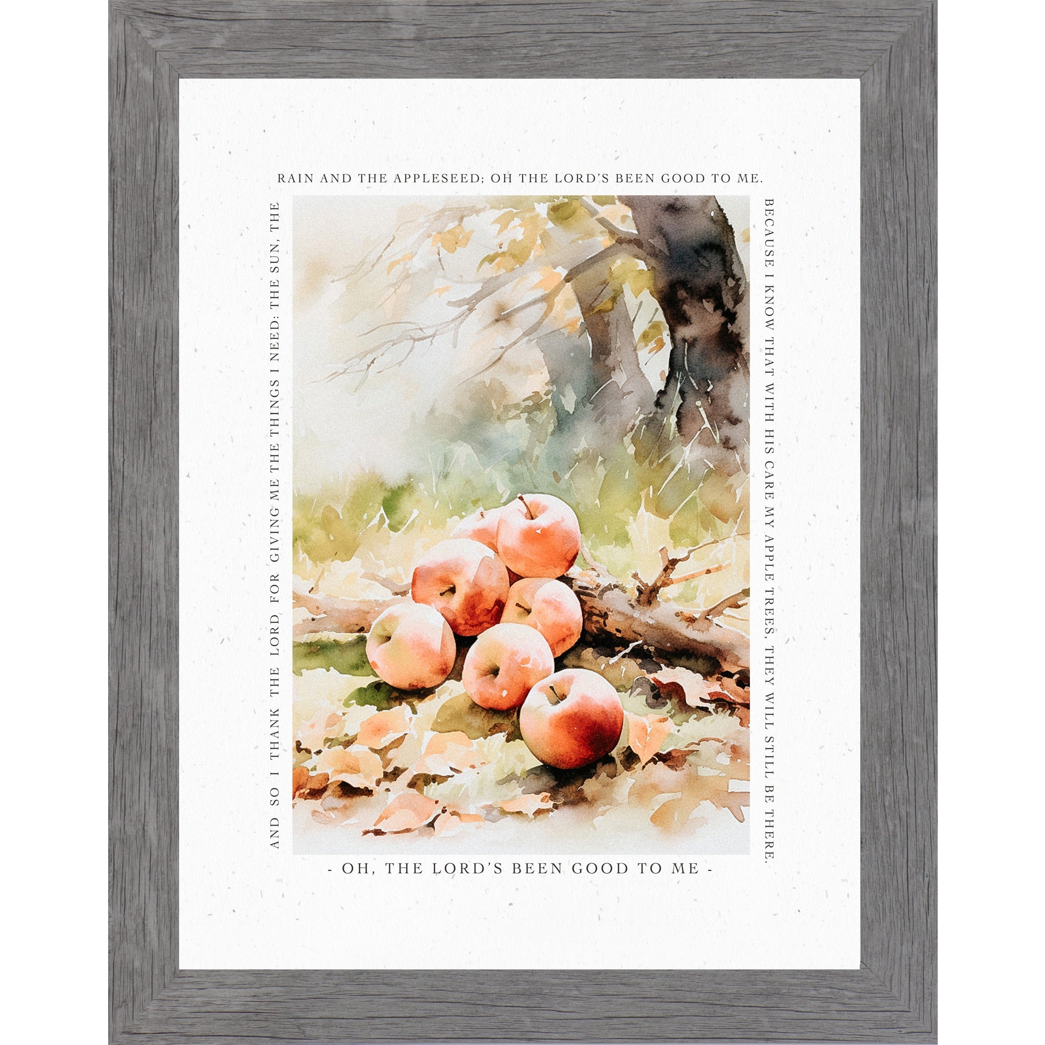 Framed wall art featuring a watercolor-style still life of several red apples on the ground with autumn leaves, surrounded by a gray wood frame and a white border with printed scripture text.