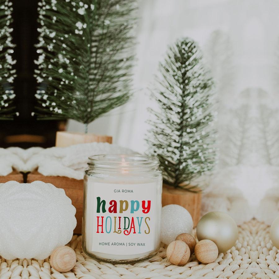 Candle labeled 'happy HOLIDAYS' with decorative elements on a textured surface.