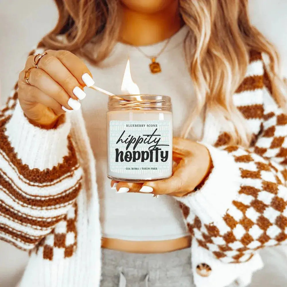 Person lighting a 'hippity hippity' candle with a wooden wick.