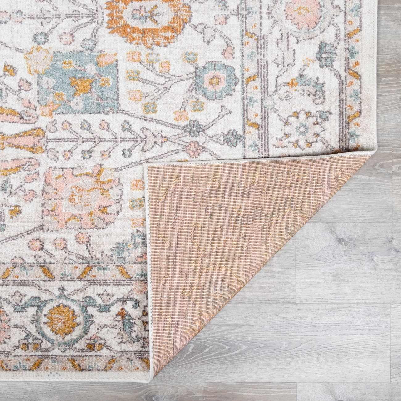 Cozy farmhouse-style rug with floral patterns and soft pastel colors on wooden floor
