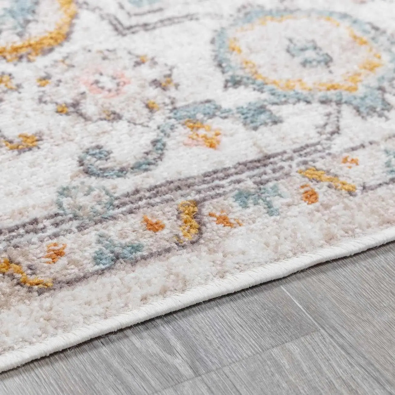 Cozy farmhouse area rug with soft pastel medallion pattern on light wood floor