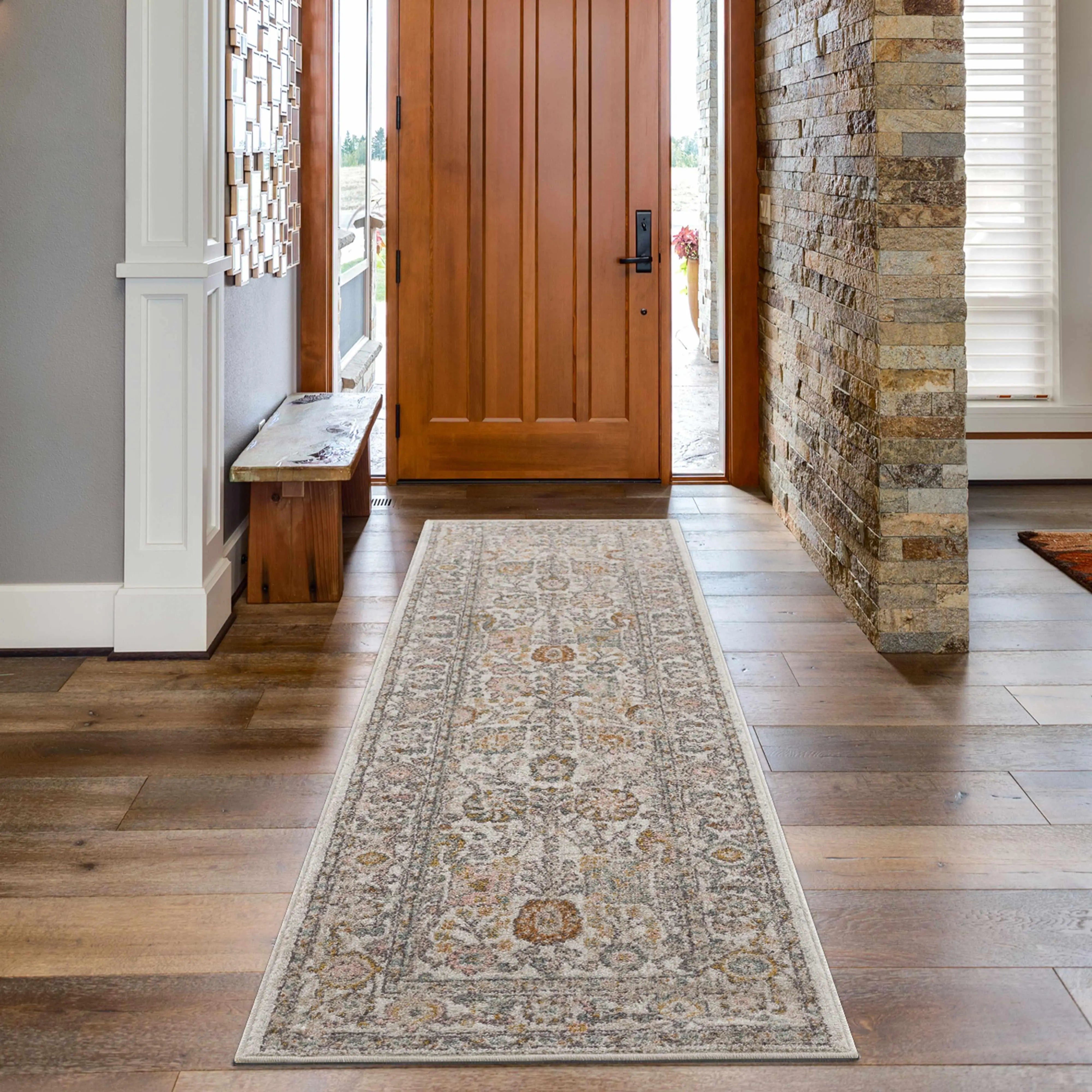 Cozy farmhouse entryway with vintage patterned runner rug, wooden door, and stone accent wall