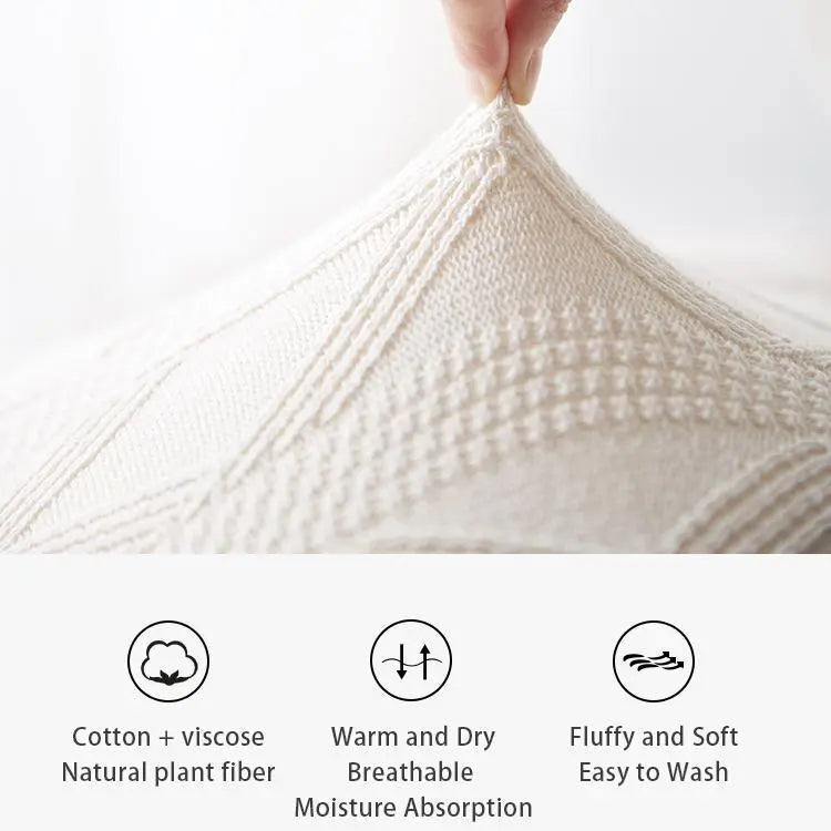 Cozy cream knit blanket with cotton-viscose blend, soft texture, and breathable warmth for farmhouse decor