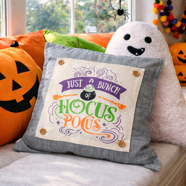 Halloween-themed pillow with text and decorative pillows in the background
