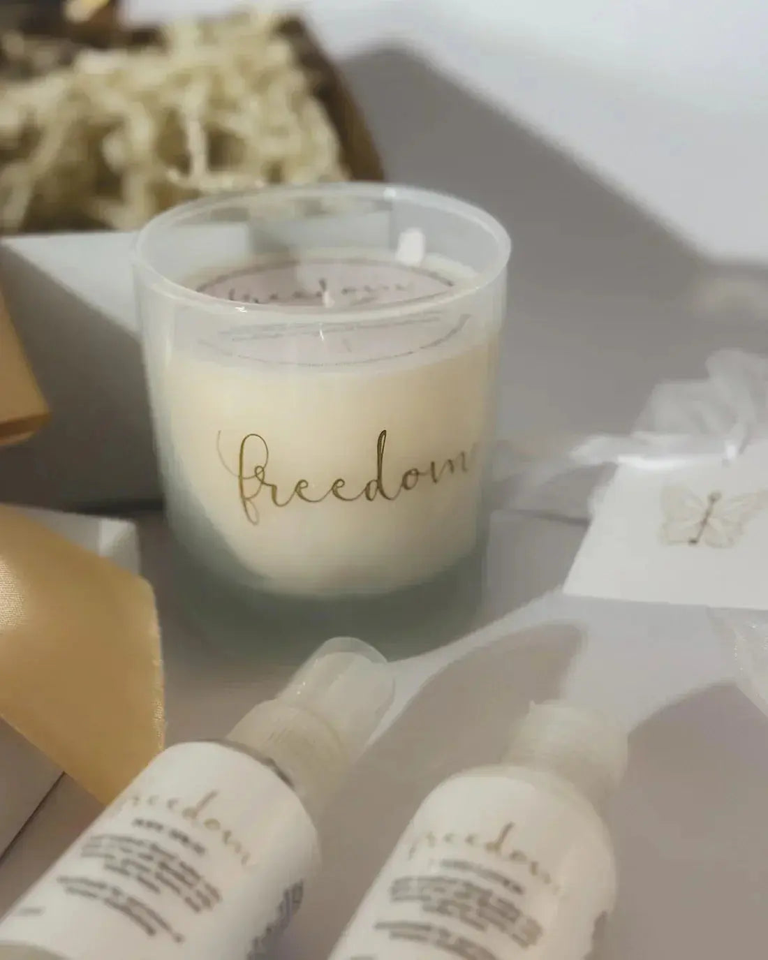 Frosted glass candle with 'freedom' script, matching sprays, and gift box for cozy home decor