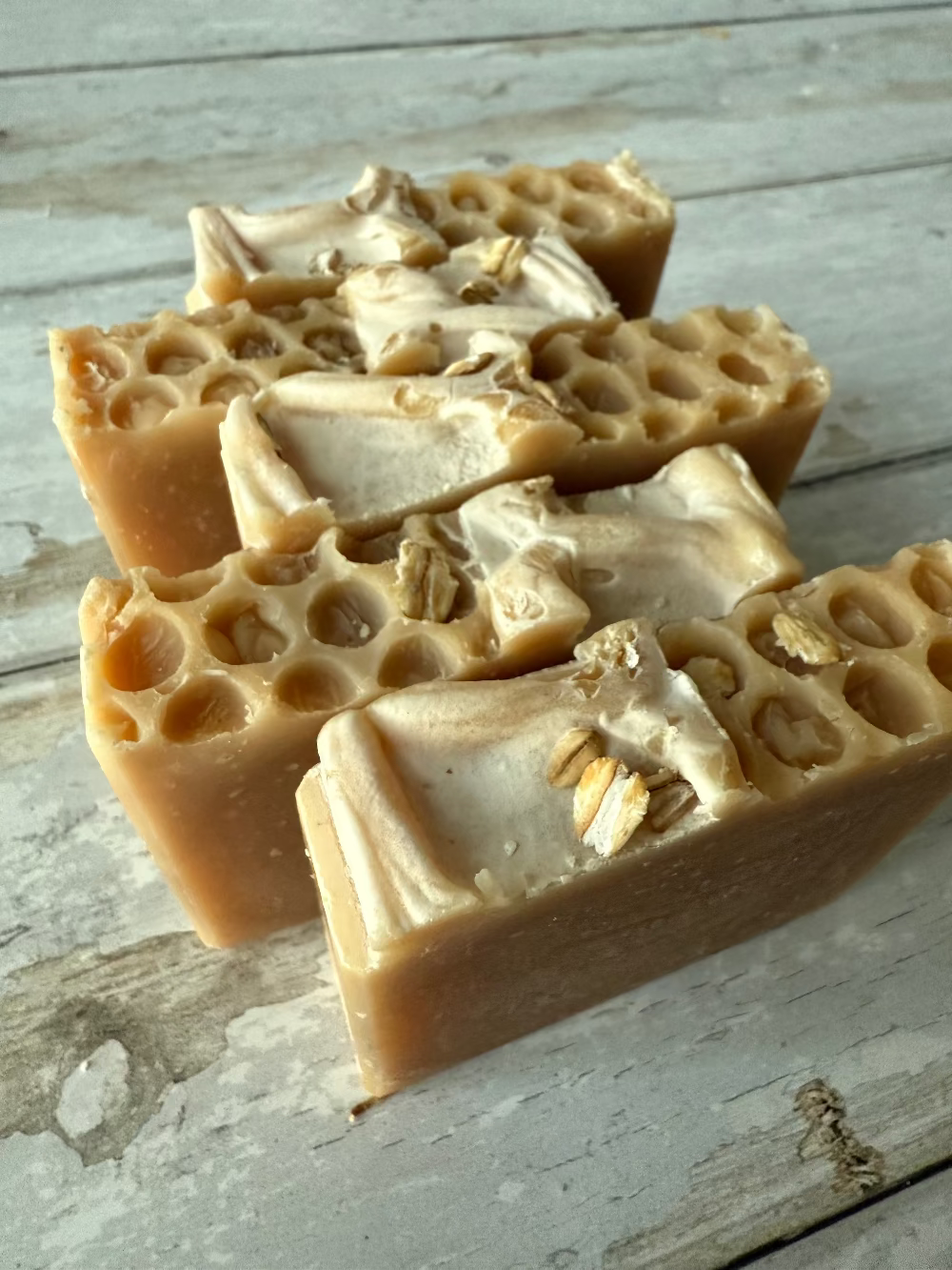 Three bars of honeycomb-textured soap on a wooden surface