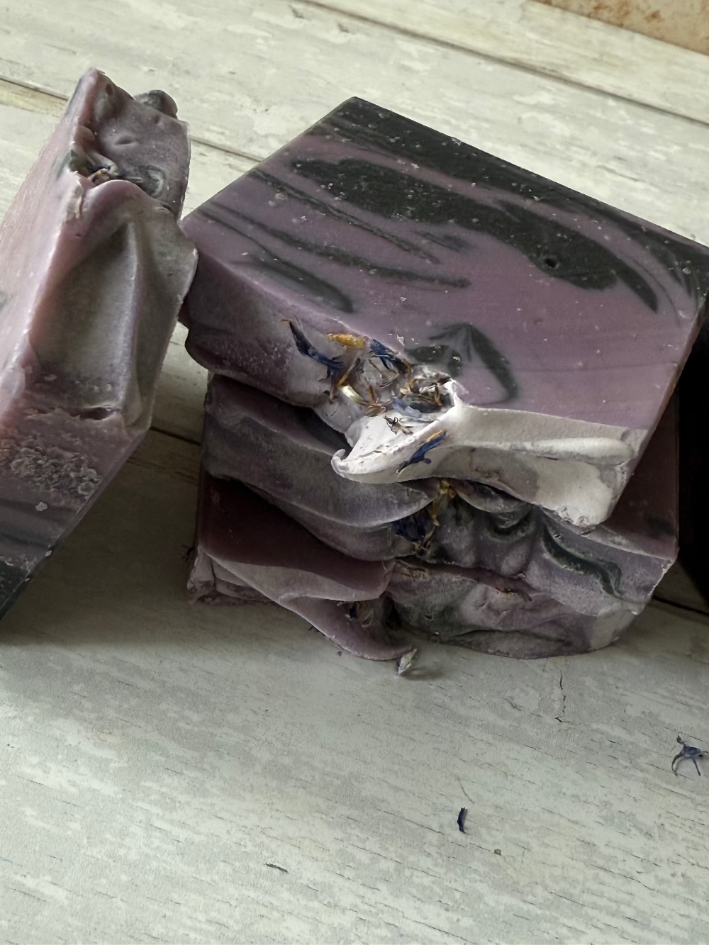 Purple soap bar with a decorative design on a wooden surface