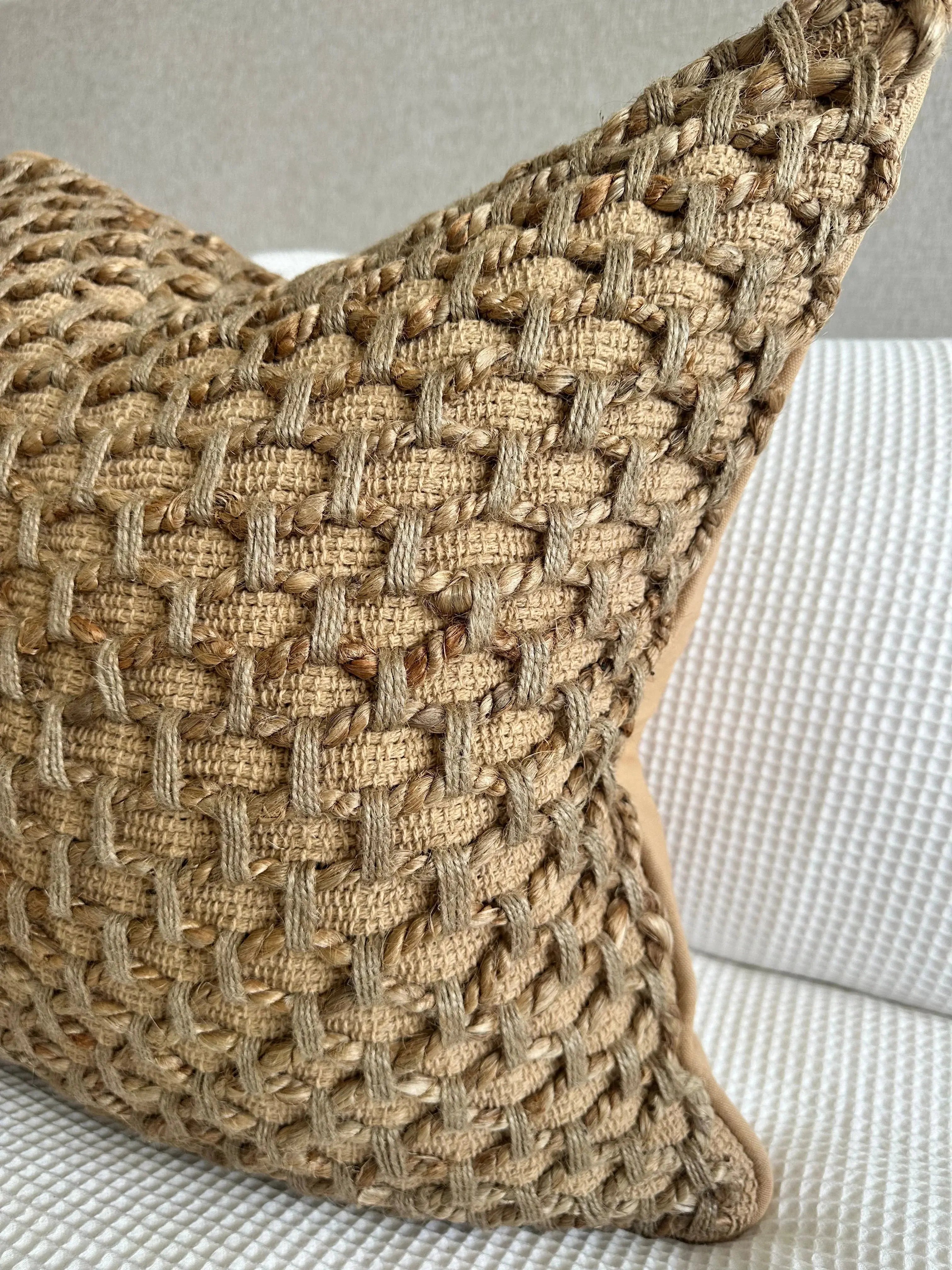 Textured woven jute pillow with natural fiber pattern, perfect for cozy farmhouse or cottage style decor.