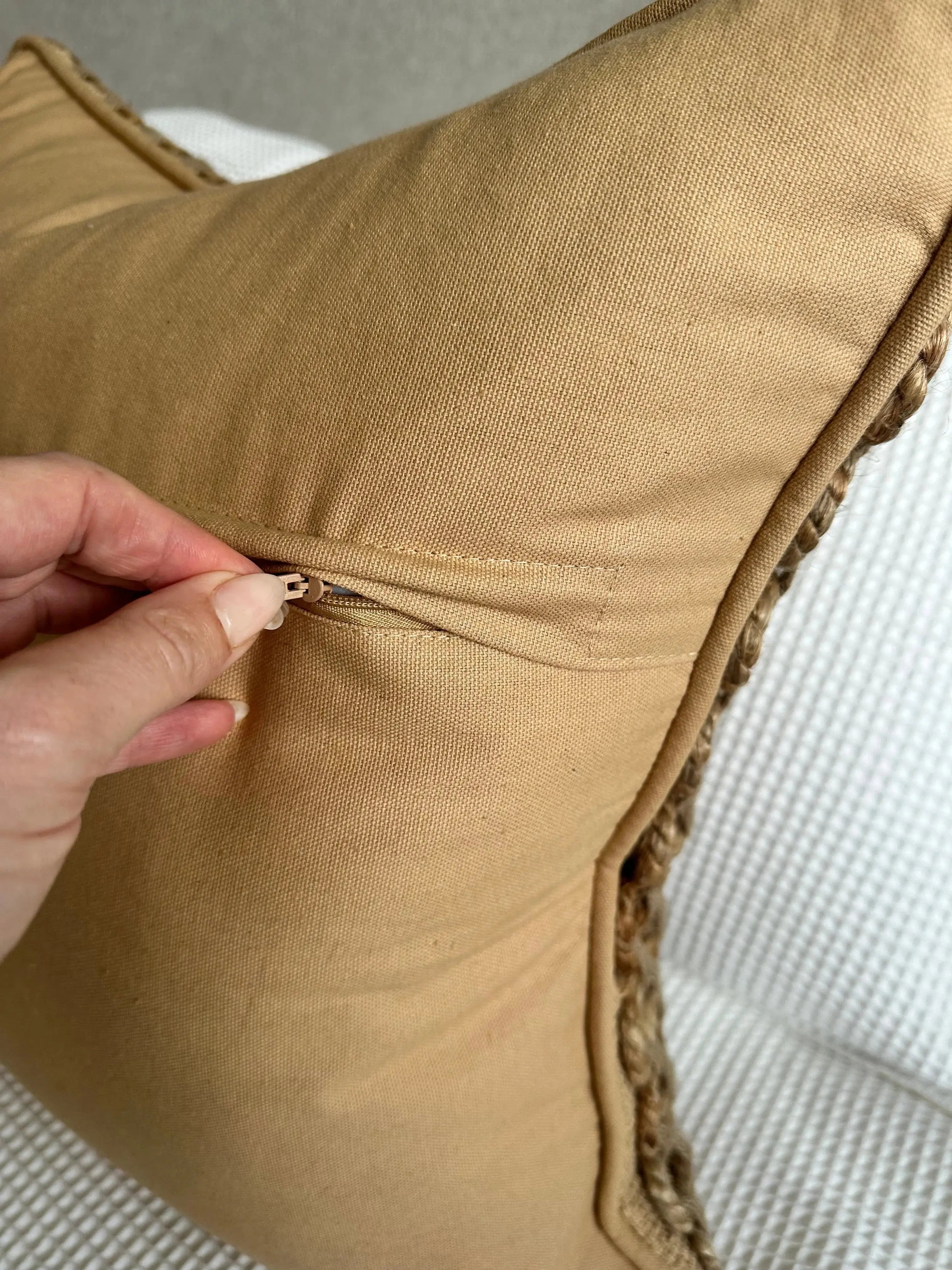 Tan farmhouse pillow with braided trim and hidden zipper, cozy cottage decor accent