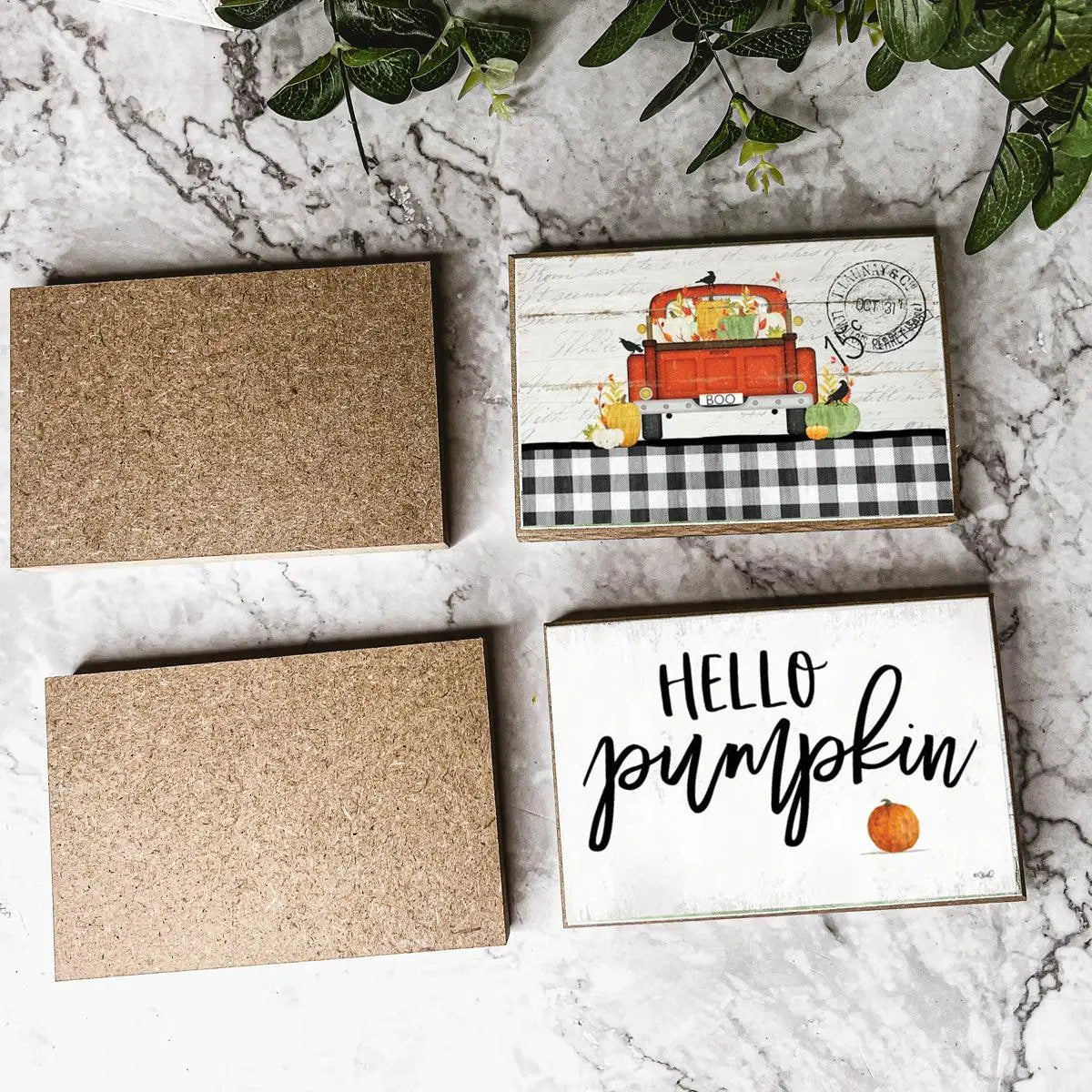 Decorative signs with a truck and 'Hello Pumpkin' on a marble surface