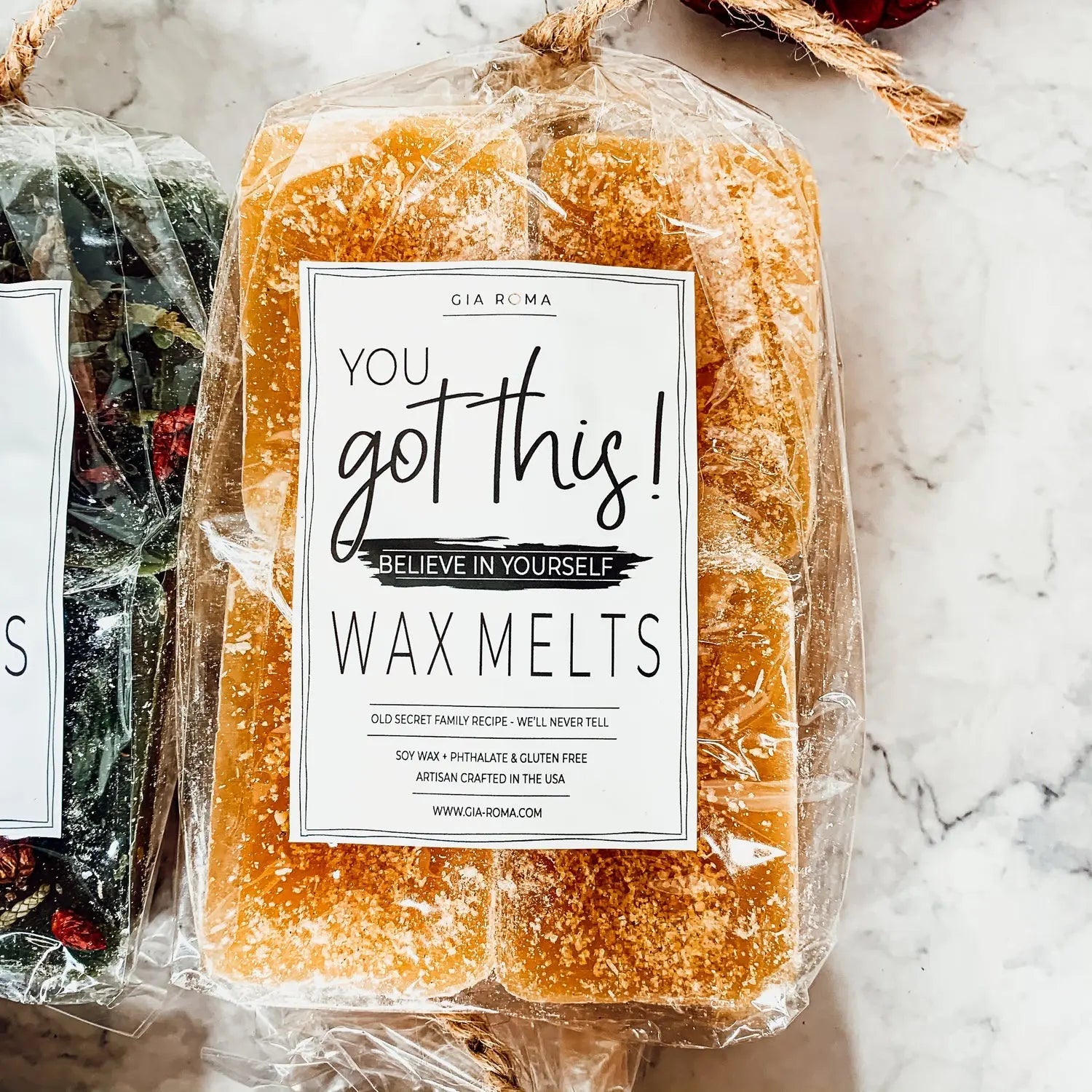 Packaged wax melts with a motivational label on a marble surface