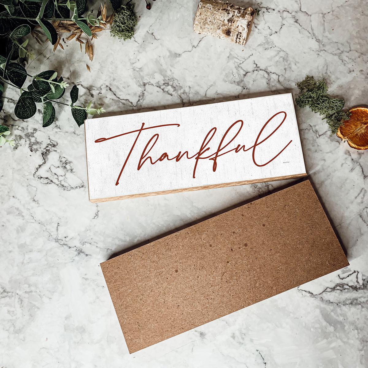 Card with 'Thankful' text on a marble surface with decorative elements