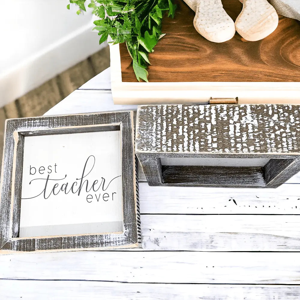 Wooden frame with 'best teacher ever' text on a white wooden surface.