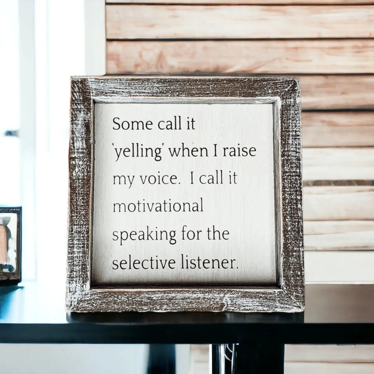 Framed quote on a table with a wooden background