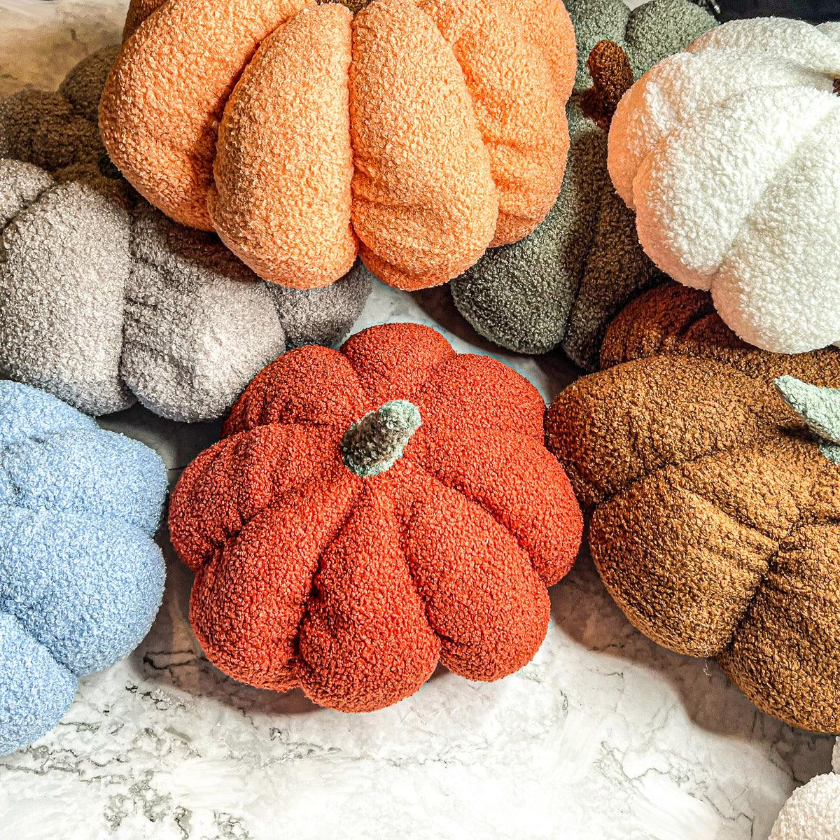Collection of textured pumpkins in various colors on a marble surface