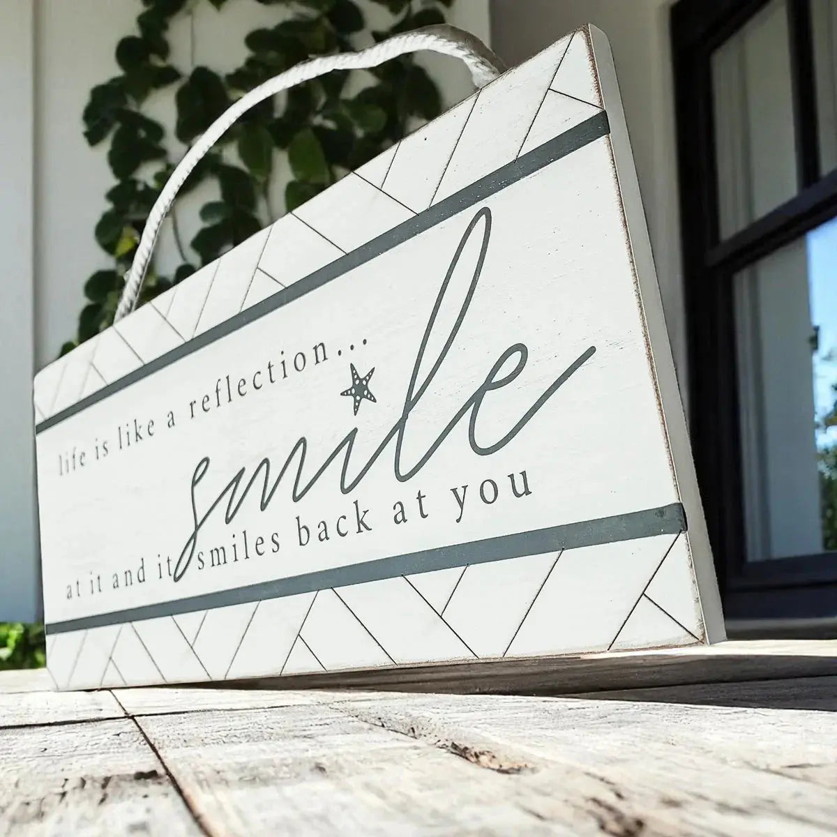 Decorative sign with motivational quote on a wooden surface