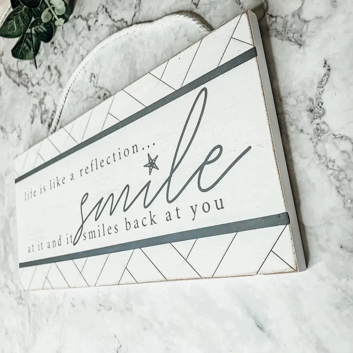 Decorative sign with motivational quote on a marble surface