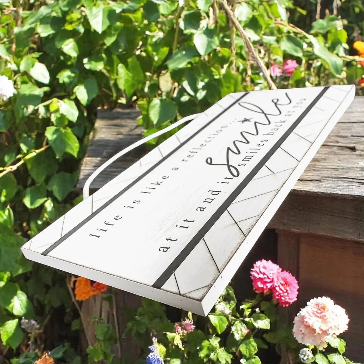 Decorative sign with 'smile' text in a garden setting