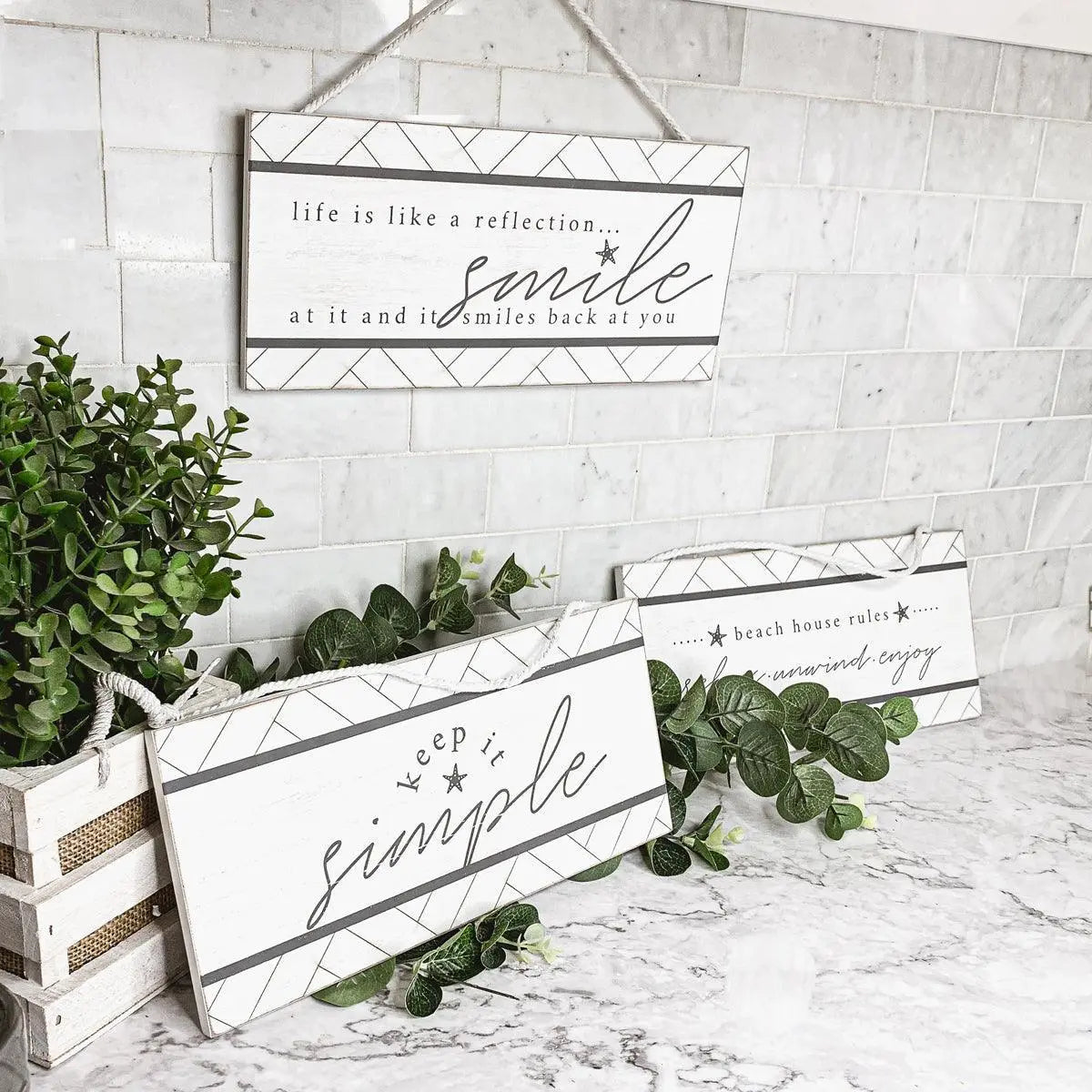 Decorative signs with motivational phrases on a marble surface with plants