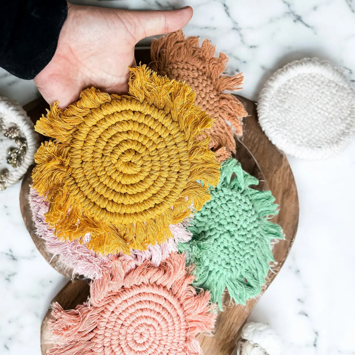 Colorful woven coasters on a marble surface