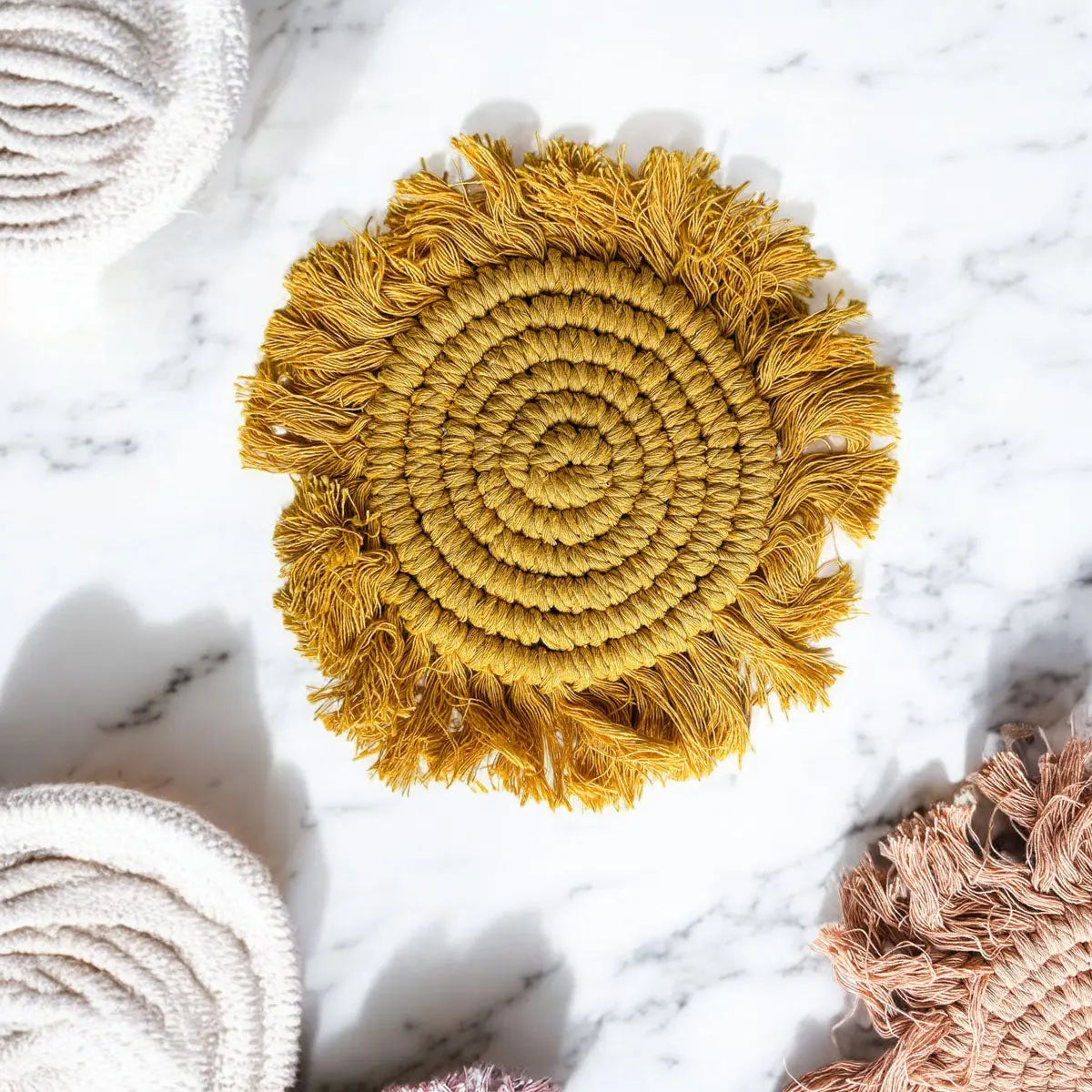 Round woven mat with fringes on a marble surface