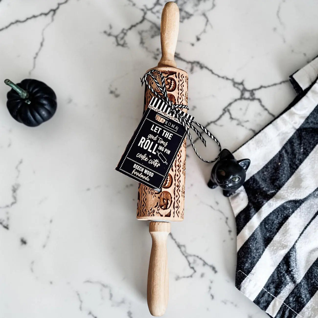Wooden rolling pin with engraved text on a marble surface