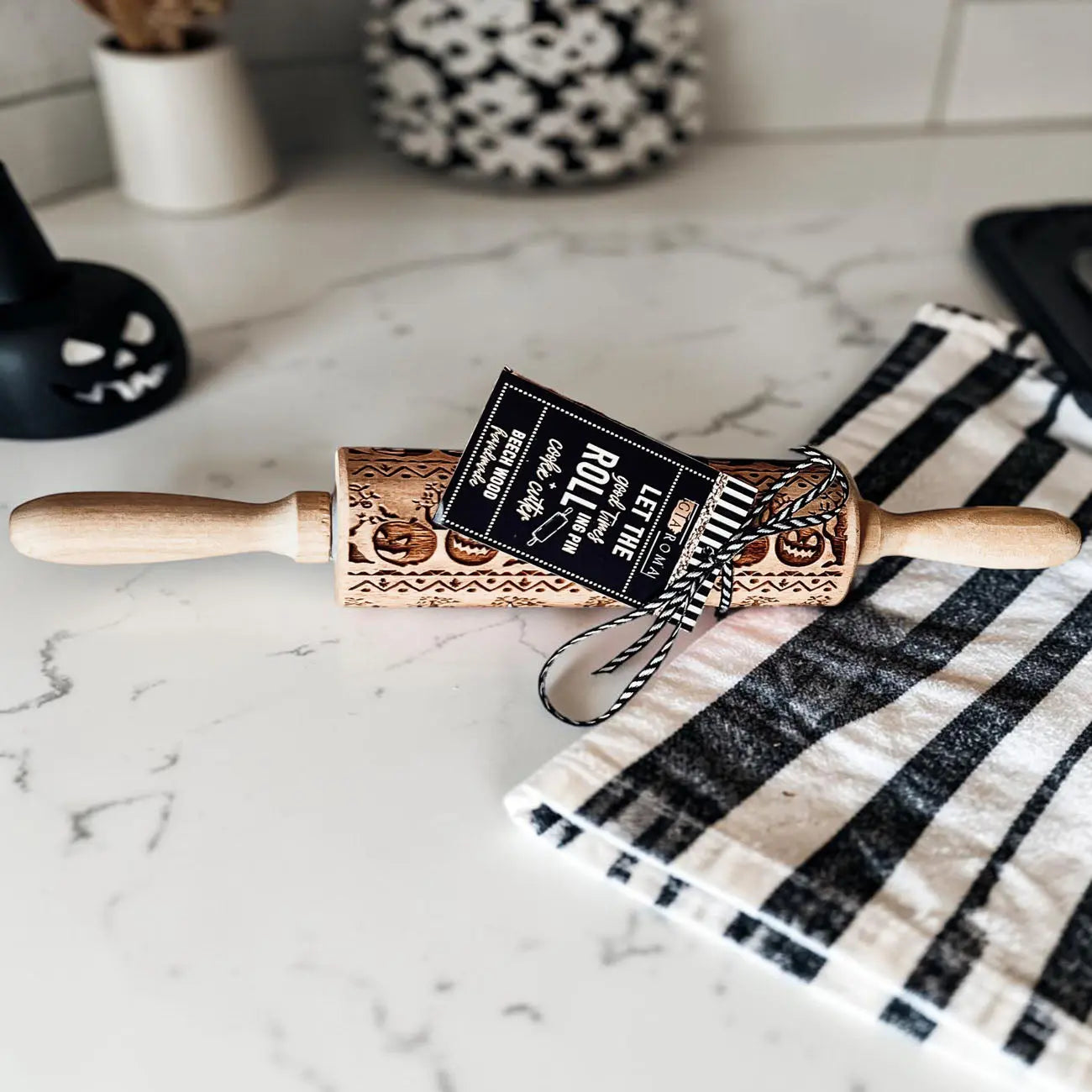 Decorative rolling pin with a label on a marble surface