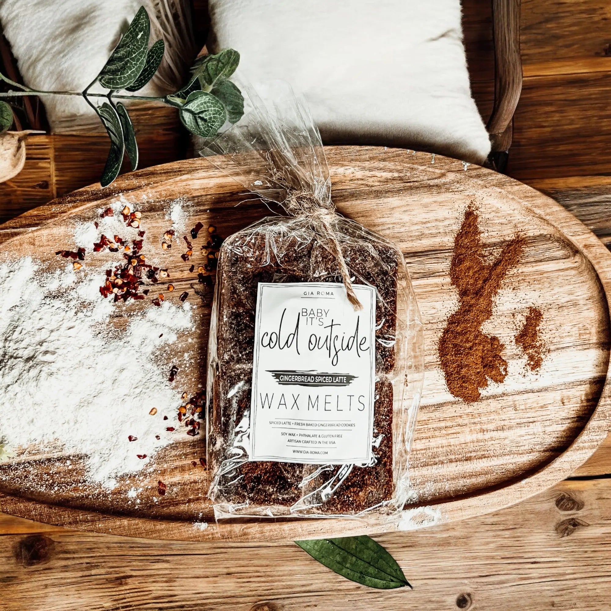 Packaged wax melts labeled 'Cold Outside' on a wooden surface with decorative elements.