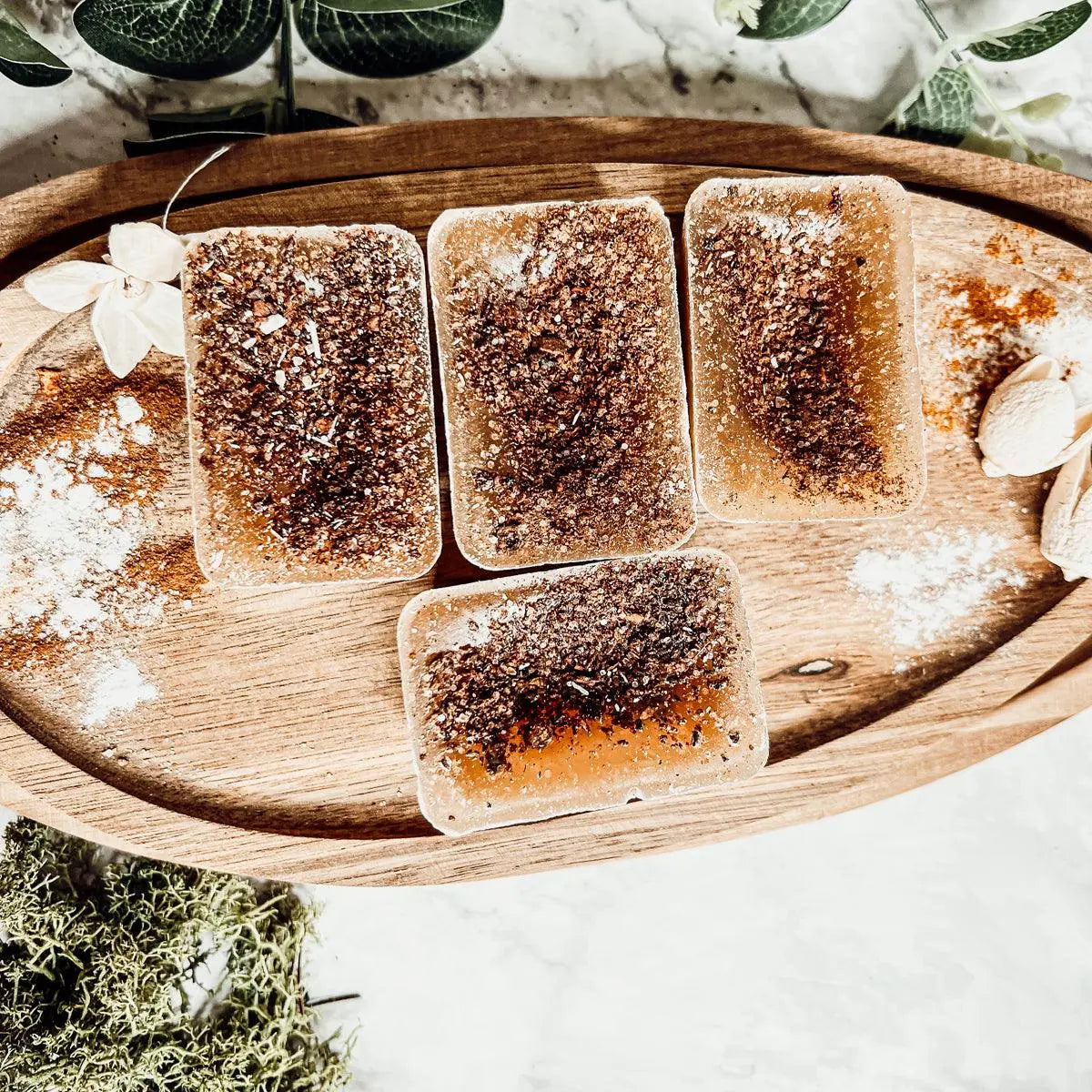 Five brown rectangular objects on a wooden tray with a natural background