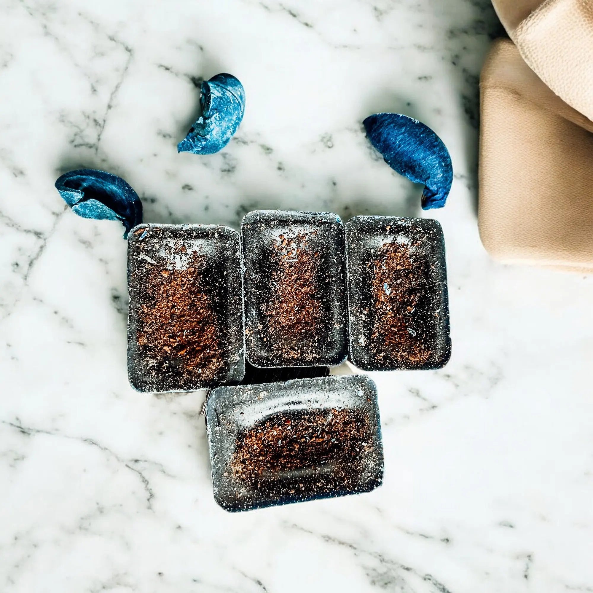 Dark chocolate truffles on a marble surface with blue decorative elements.