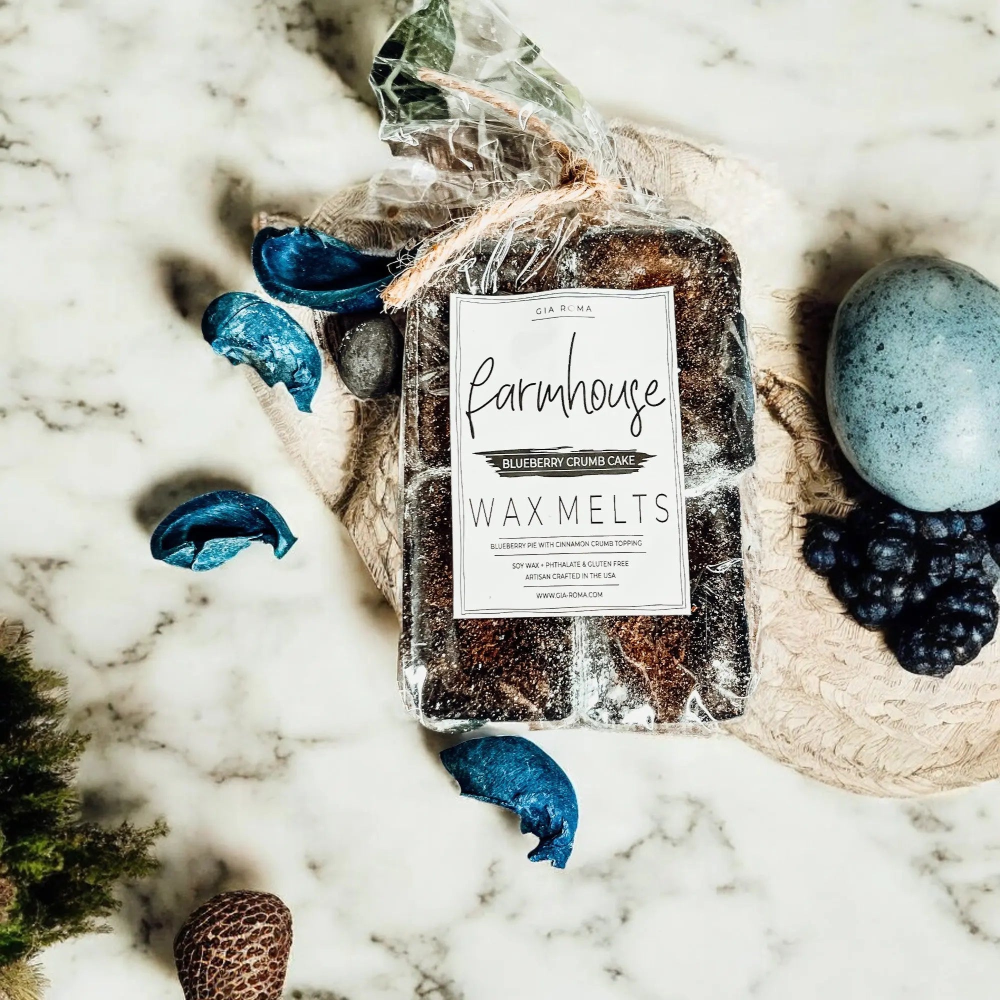 Pack of Farmhouse Wax Melts on a marble surface with decorative elements.