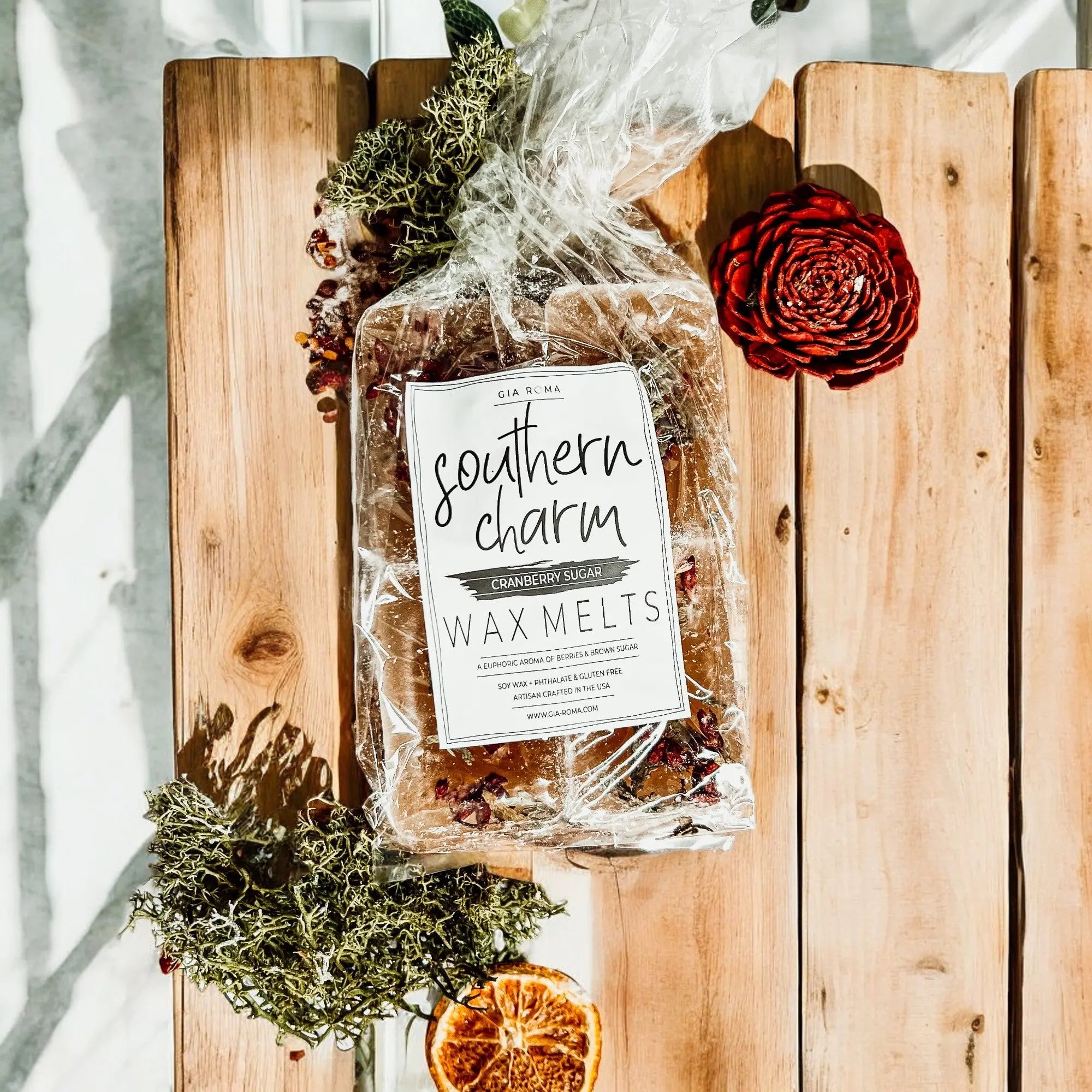 Packaged wax melts labeled 'Southern Charm' on a wooden surface with decorative elements.