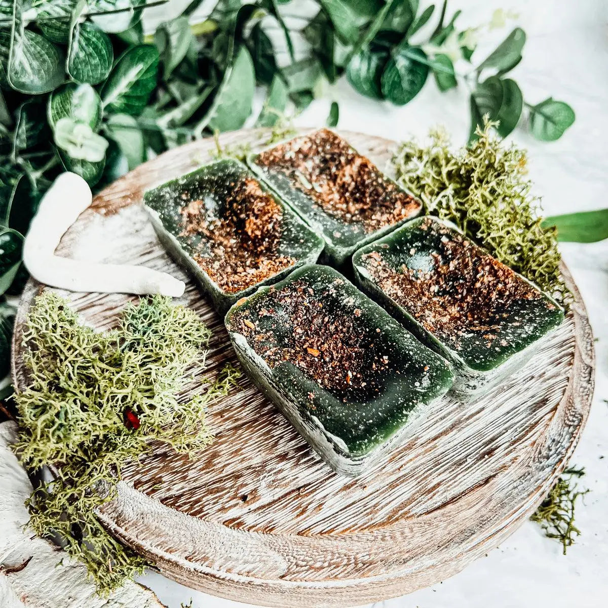 Green soap bars on a wooden tray with greenery