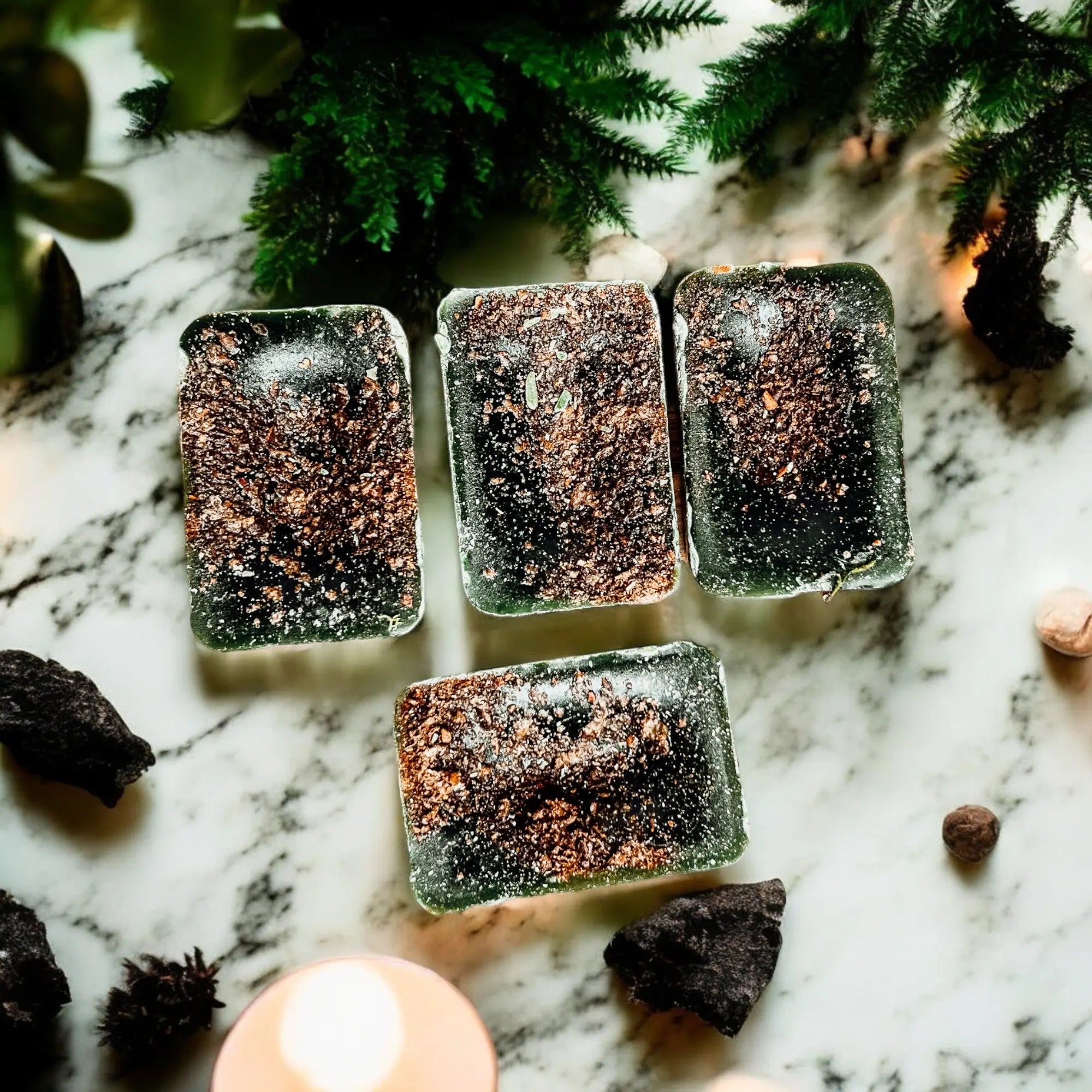 Frozen blocks of a dark substance on a marble surface with greenery in the background