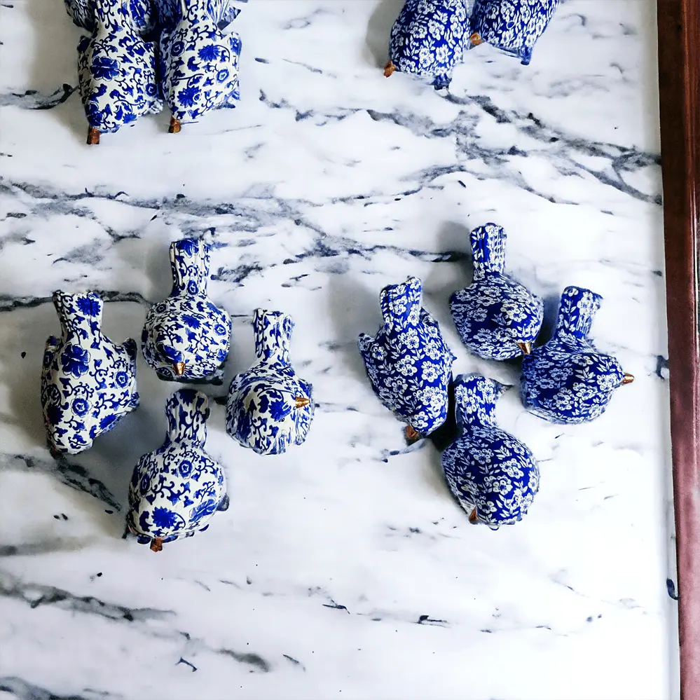 Blue and white ceramic ducks on a marble surface